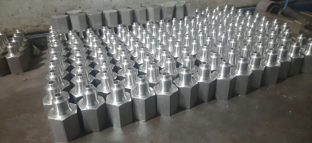 Large quantity of small hexagon-base nozzles or fittings arranged on a workbench