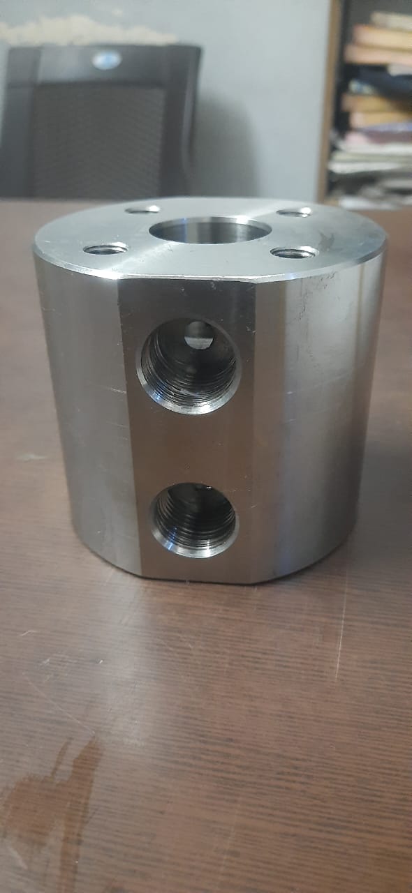Cylindrical metal block with multiple threaded ports and mounting holes
